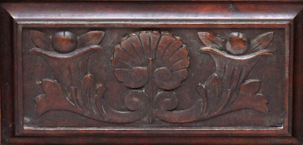 The carved door of the piano bench cupboard